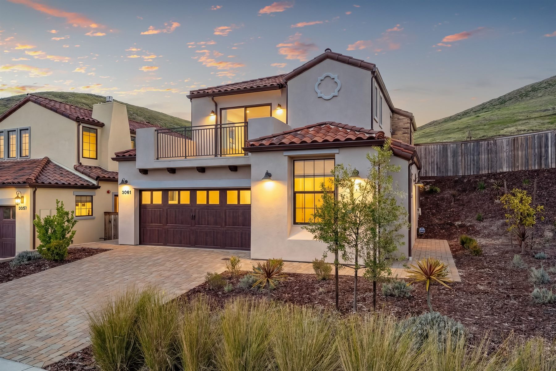 A two-story Spanish-style home glowing warmly at twilight, professionally prepared and photographed for its listing