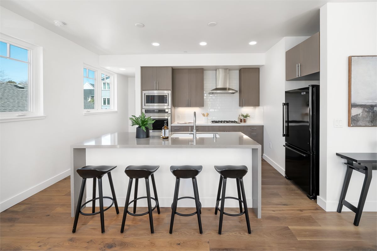A modern, spotless kitchen with island seating, styled for its listing debut