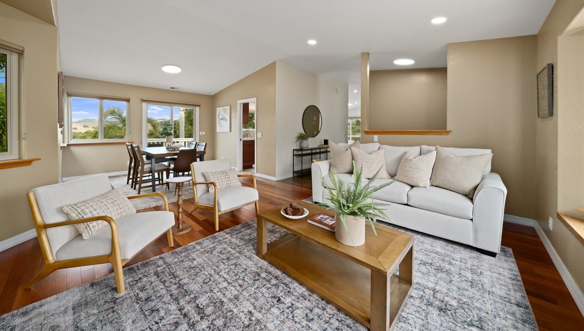A staged, spotless living and dining room with rich wood floors, detailed and ready for showings